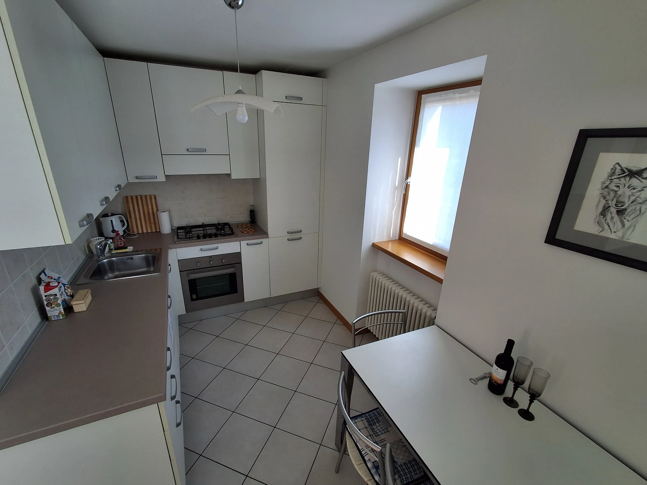 Cucina attrezzata con piano cottura a gas, forno e tavolo da pranzo